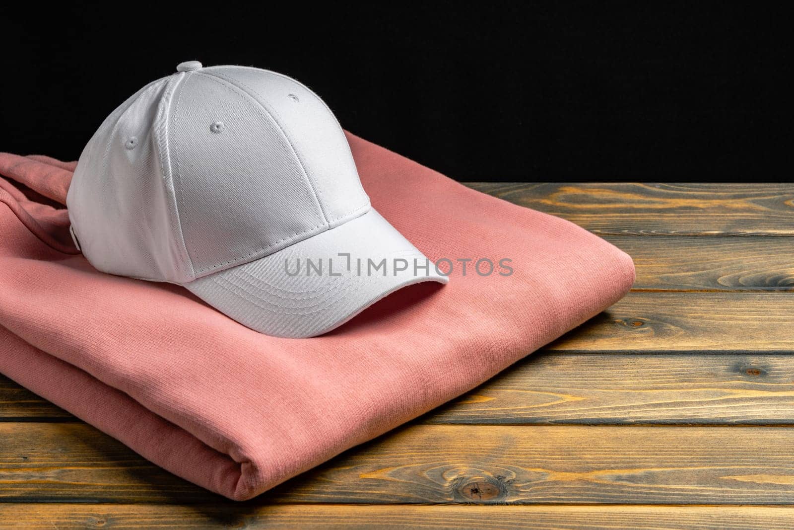 Trainers and baseball cap on wooden background close up