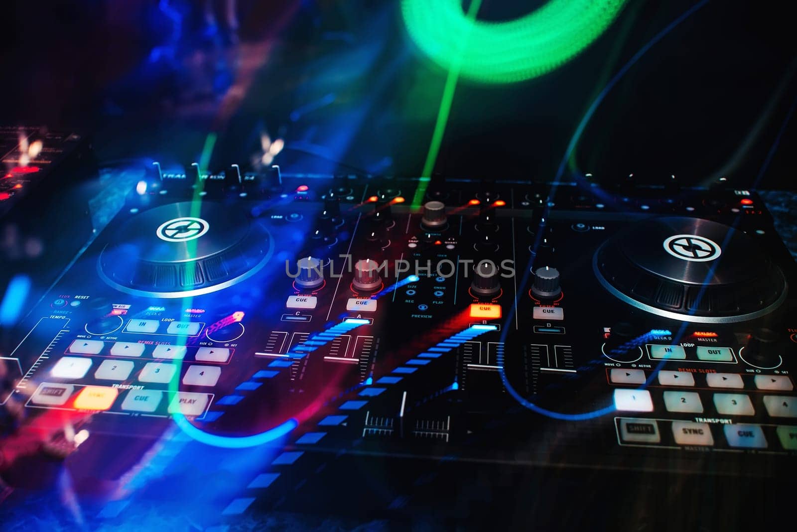 music console and DJ mixer in night club with colorful effects on a dark background