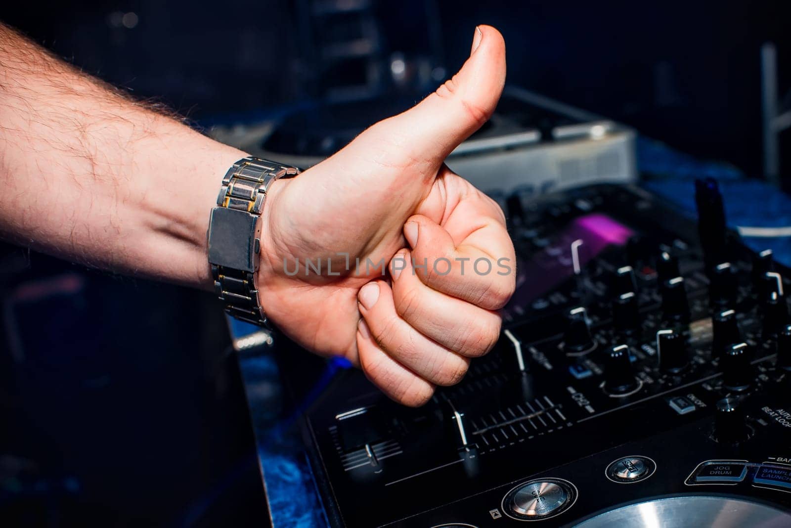 hand of DJ shows the class background of switchers and remote control in the nightclub