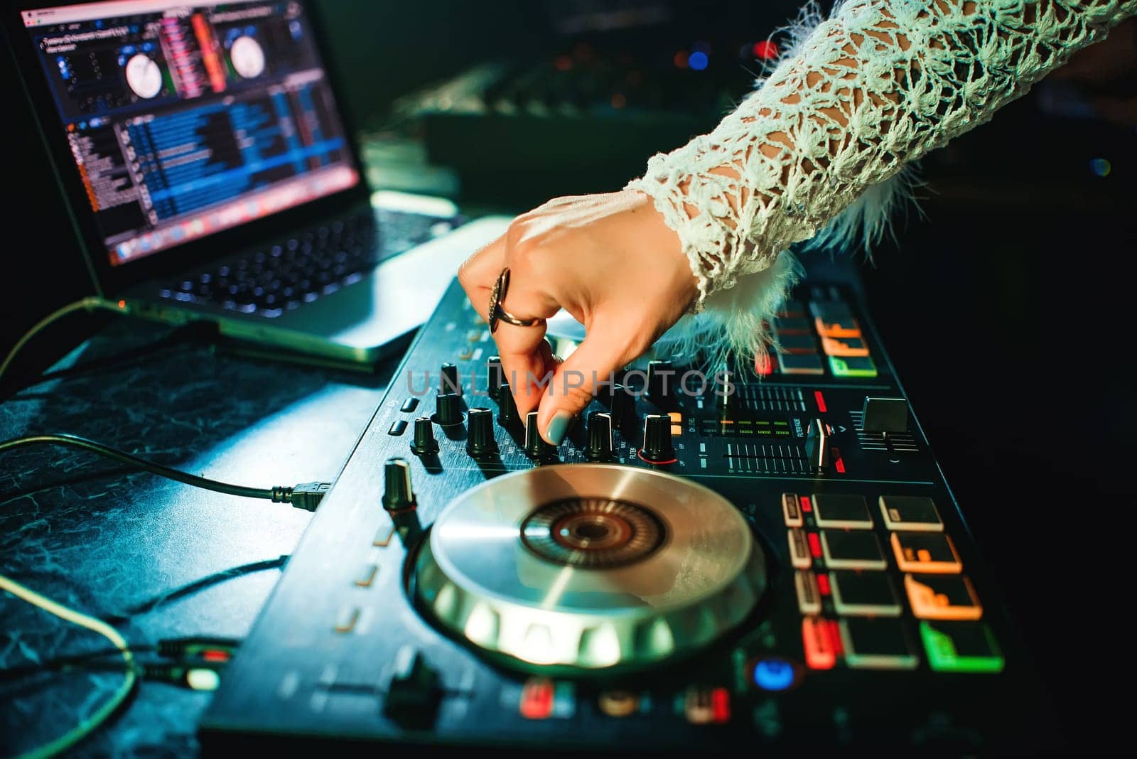 hand girl DJ with make-up and ring mixing music on professional Board