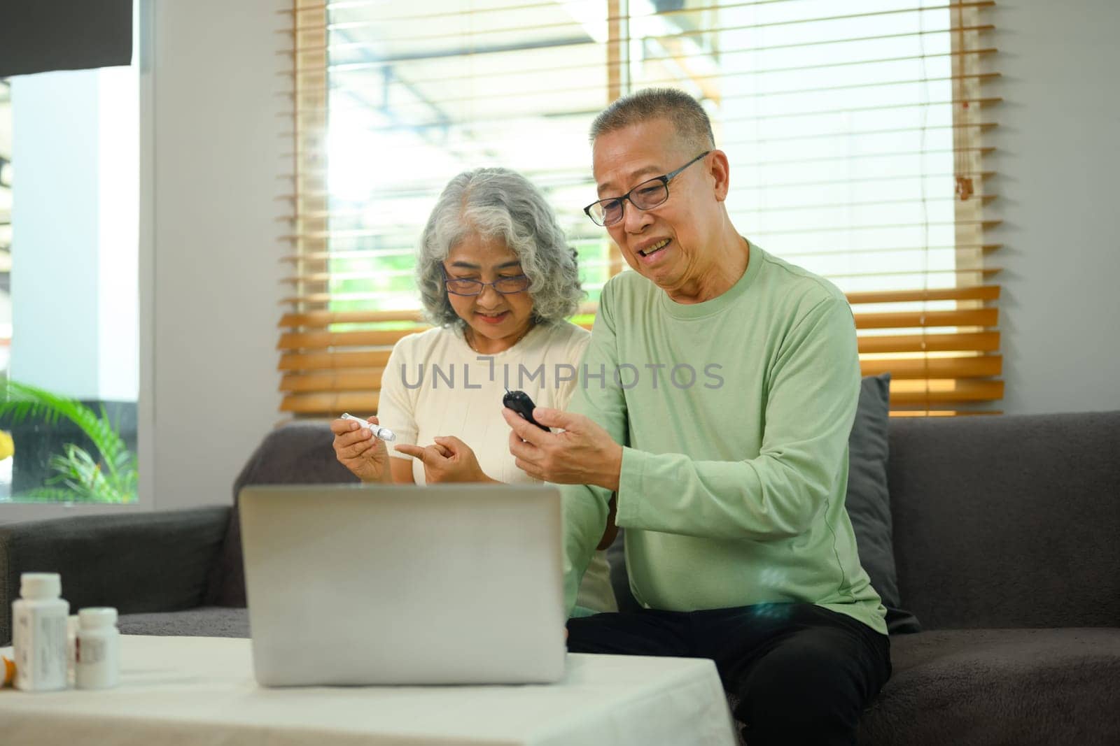 Older couple having a virtual appointment with doctor online via laptop. Telehealth concept.