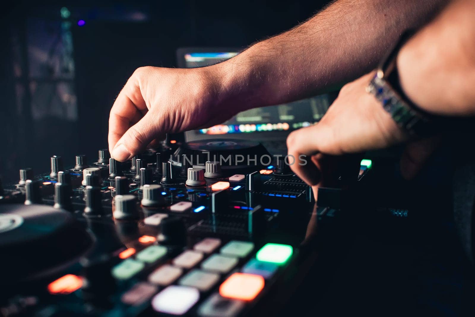 DJ mixes the track in nightclub at party hands driving controllers