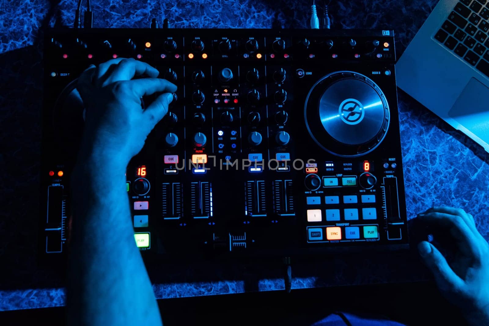 hands of DJ and professional music equipment mixer controlling buttons and levels music the view from the top