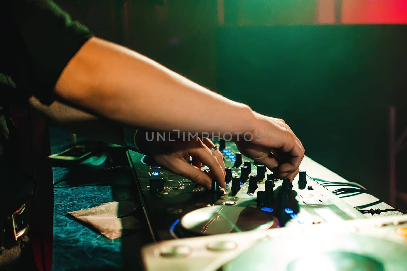 DJ mix music hands in the night club at the event on the mixer