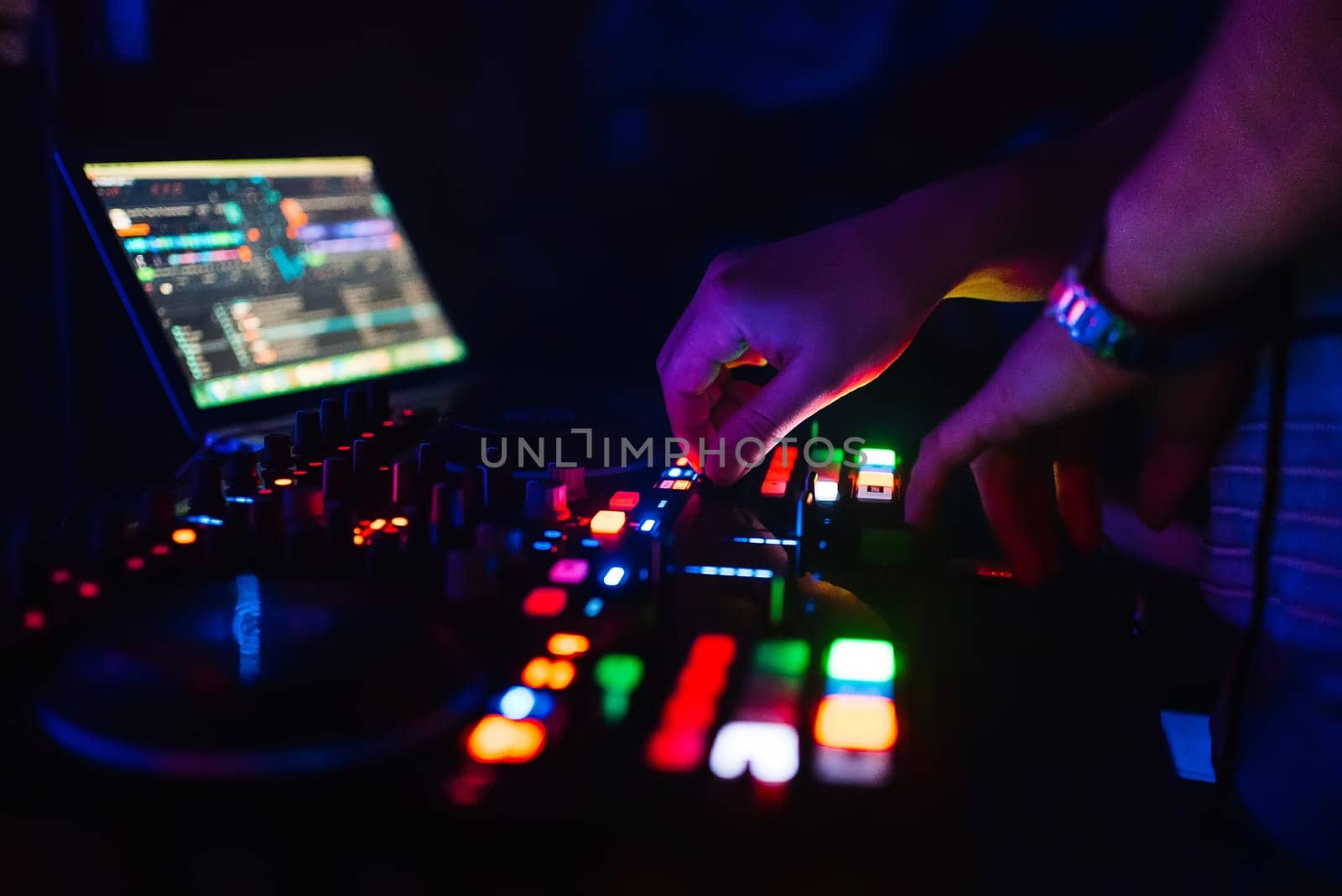 hands of a professional DJ playing and mixing music for a slumber party and the torque controllers of the console