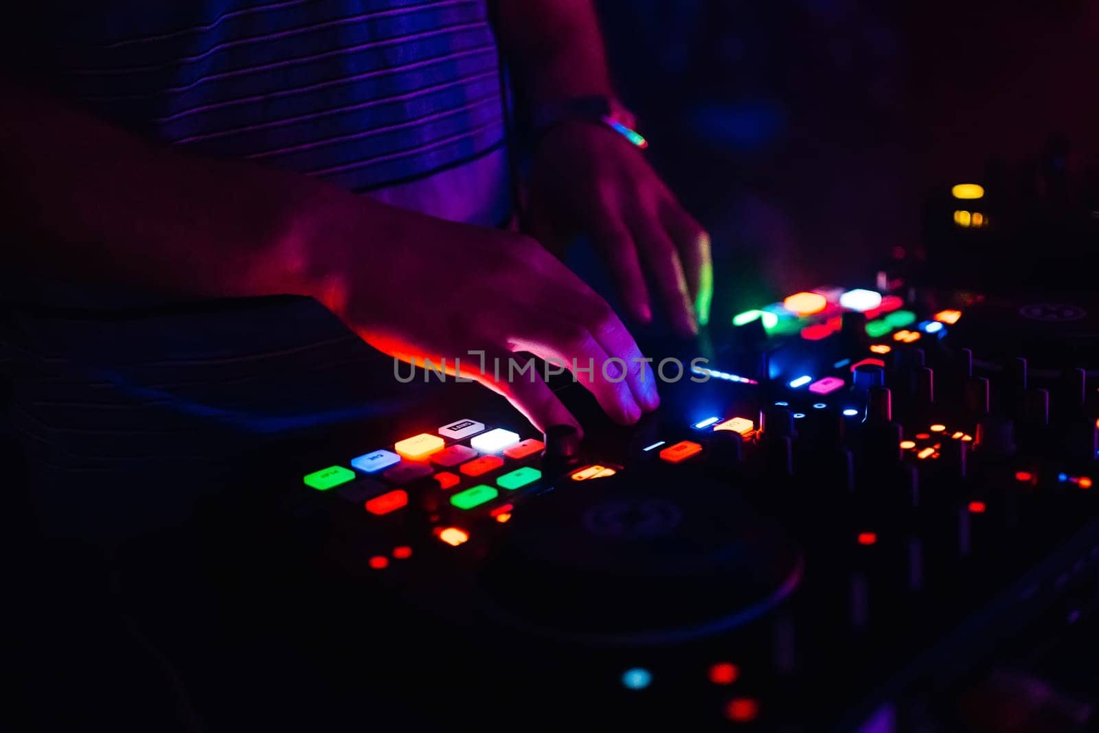hands of modern DJ professional mixer and music Board of the controlling buttons and levels club music