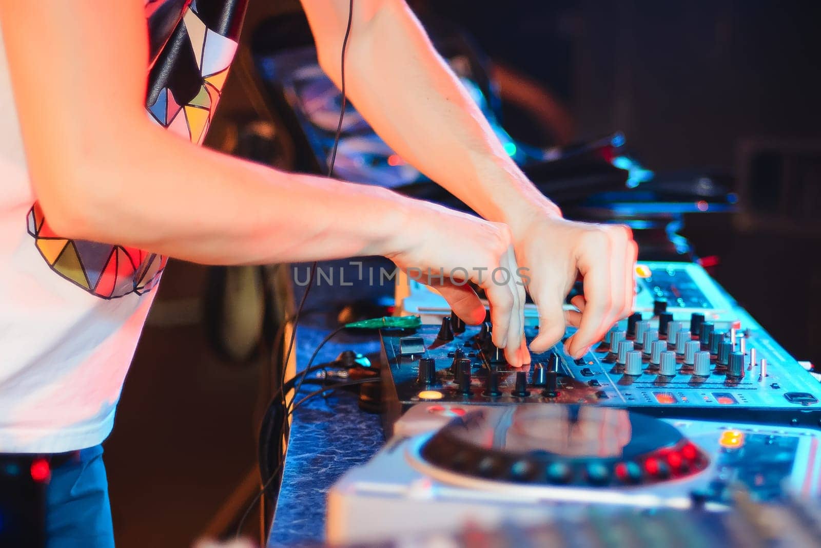 hands of the DJ on the mixer playing club music at the party