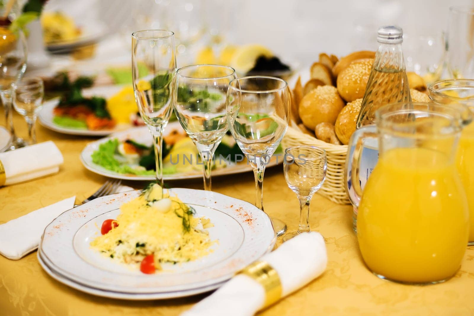 table covered with food and dishes with glasses on a tablecloth in a restaurant for holiday