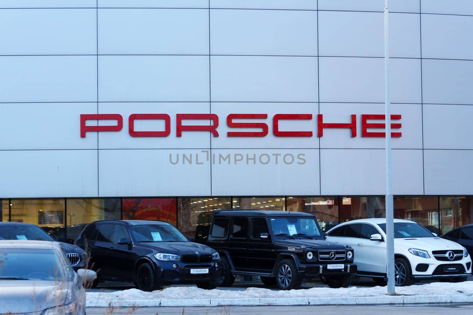 Tyumen, Russia-March 18, 2024: Vehicles parked outside a Porsche dealership, showcasing luxury cars and the iconic Porsche logo. by darksoul72
