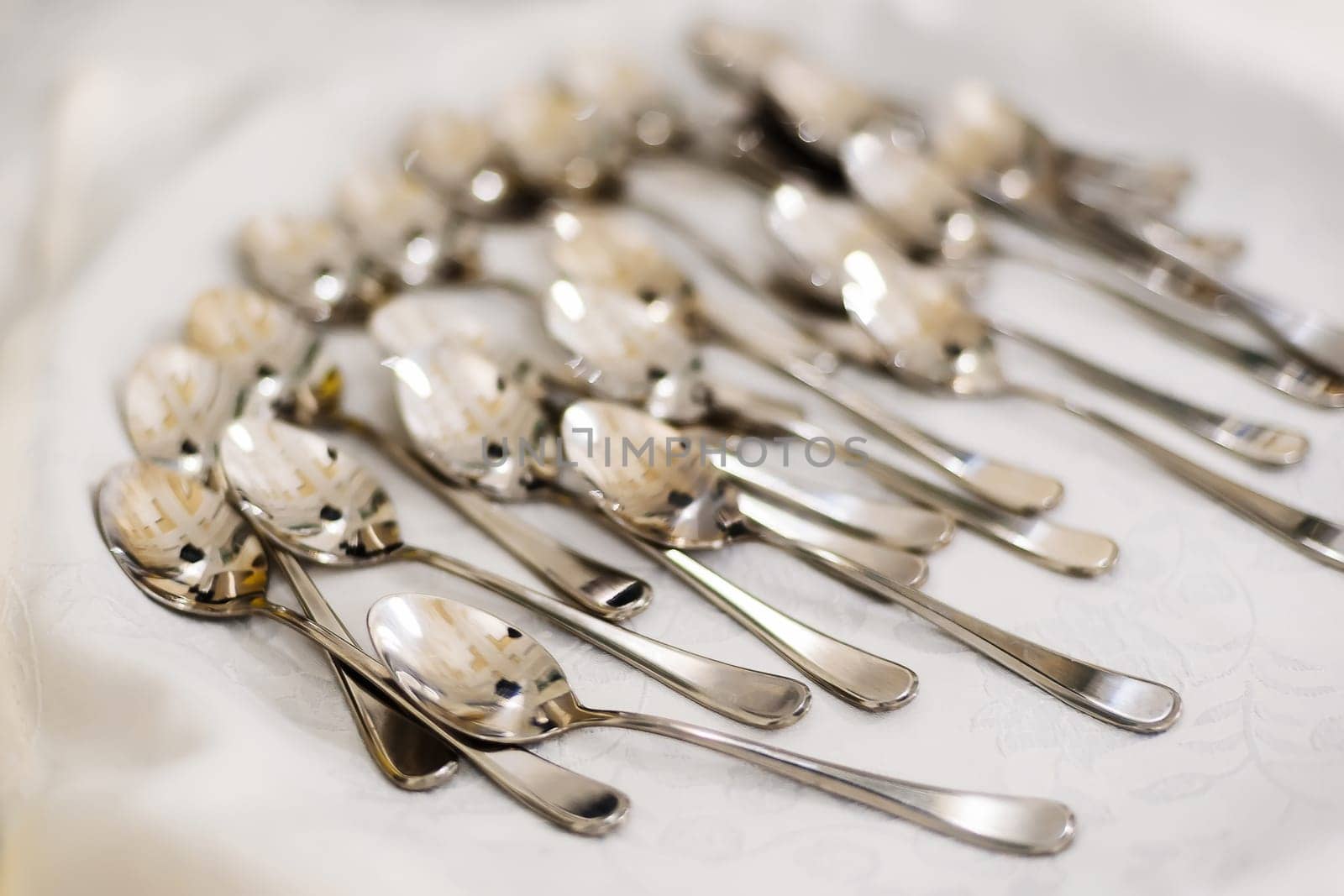 group of teaspoons on tablecloth on a table in a restaurant