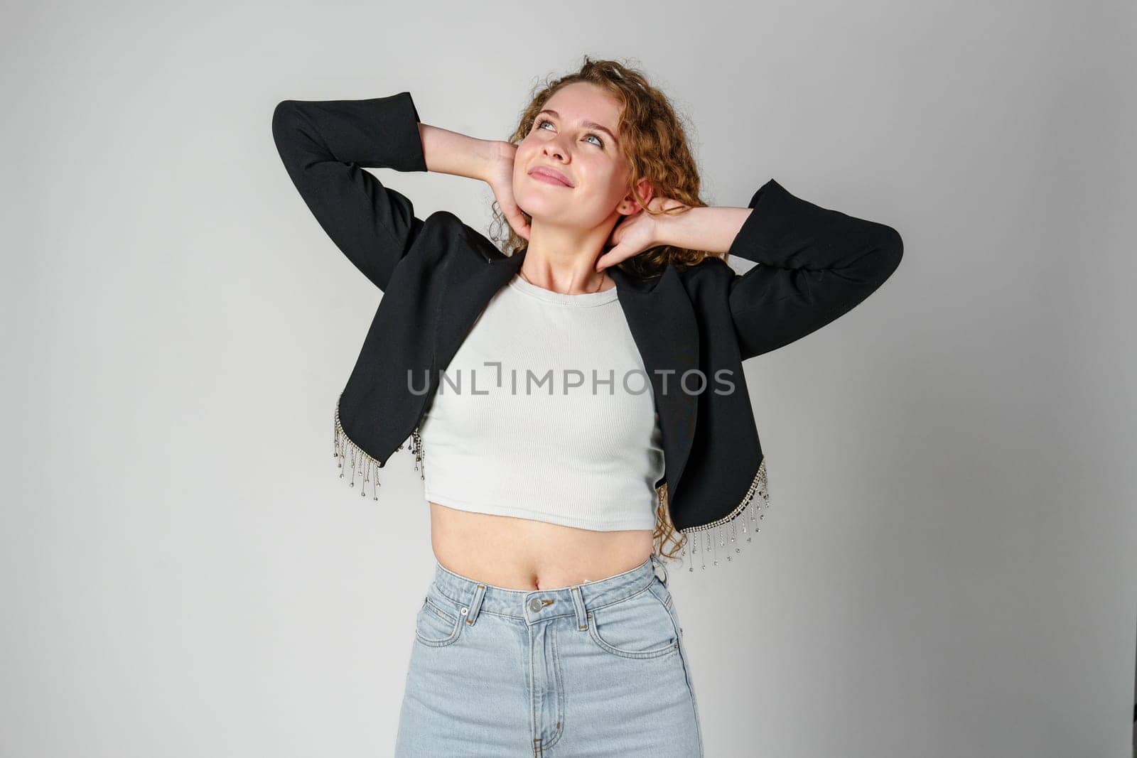Young Woman With Curly Hair Portrait against gray background by Fabrikasimf