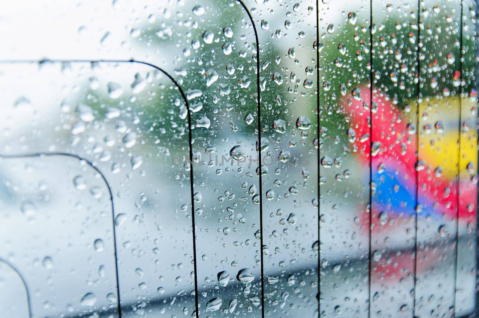 raindrops on the surface of the car glass in rainy weather with a blurred background on the street