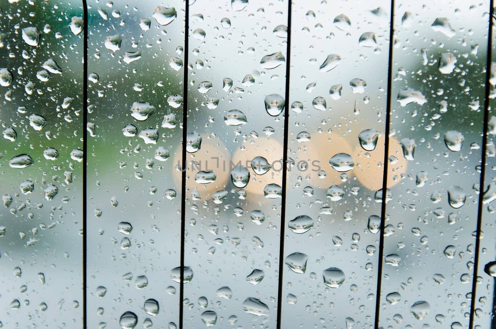 raindrops on the surface of the car glass in rainy weather with a blurred background on the street