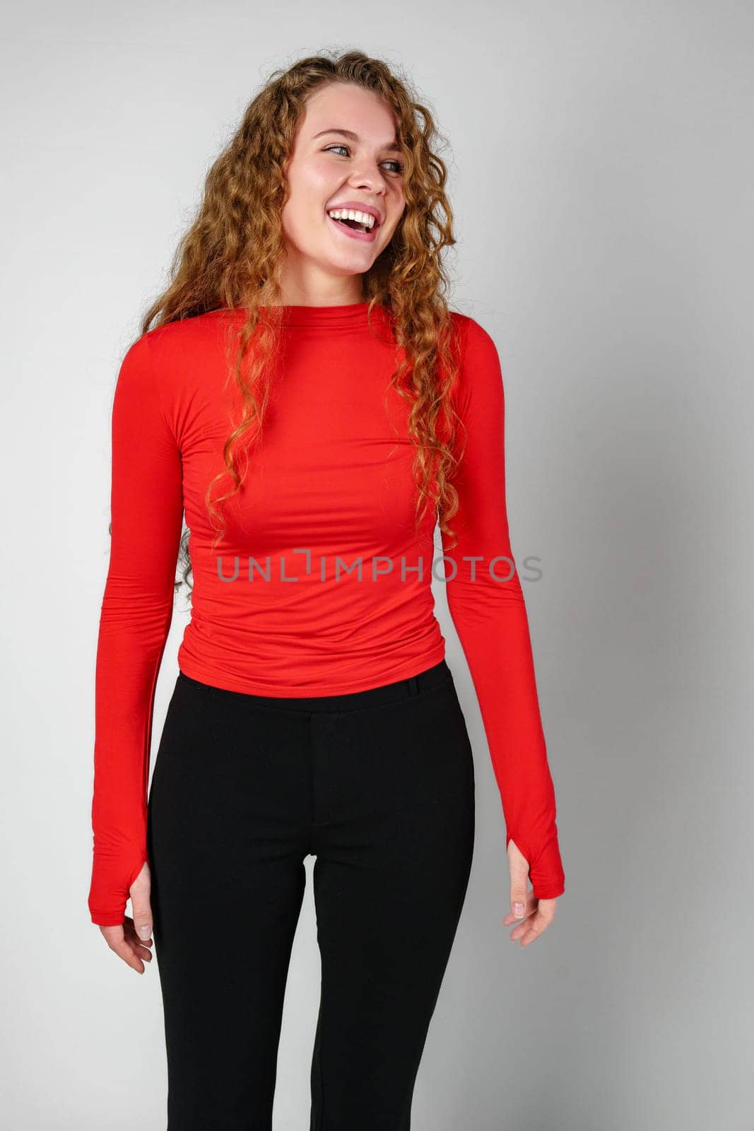 Young Woman With Curly Hair Portrait against gray background in studio