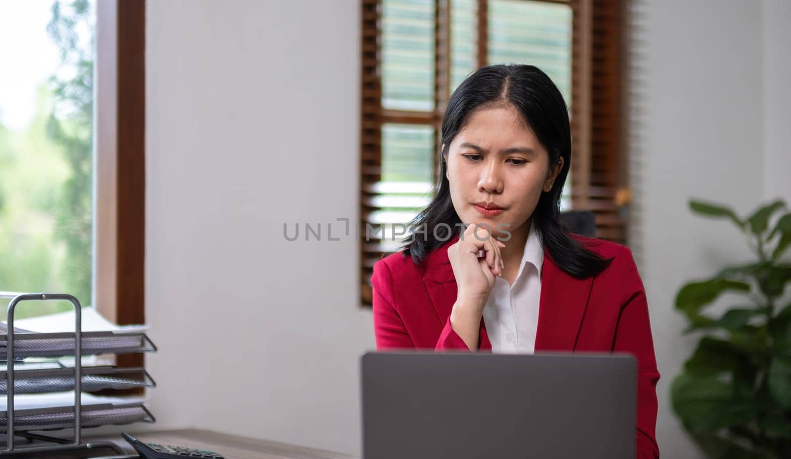 Young businesswoman has problems with her work in the office Feeling stressed and unhappy, showing a serious expression.
