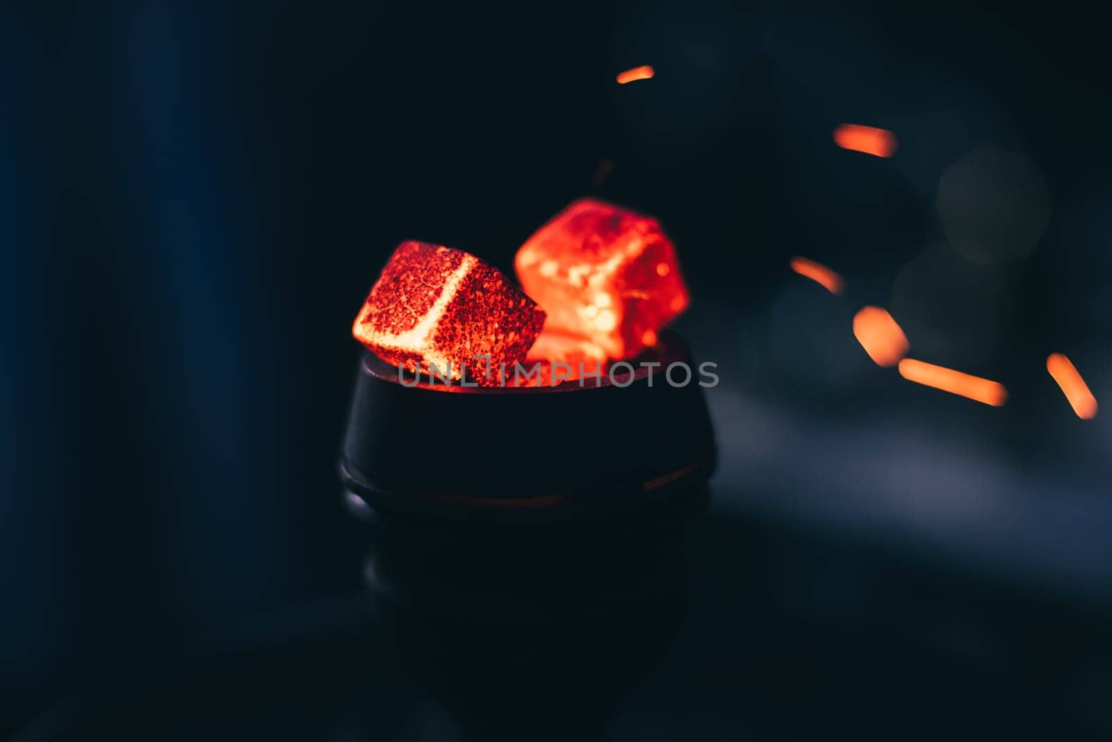 hot red coals for hookah with sparks on dark background close up