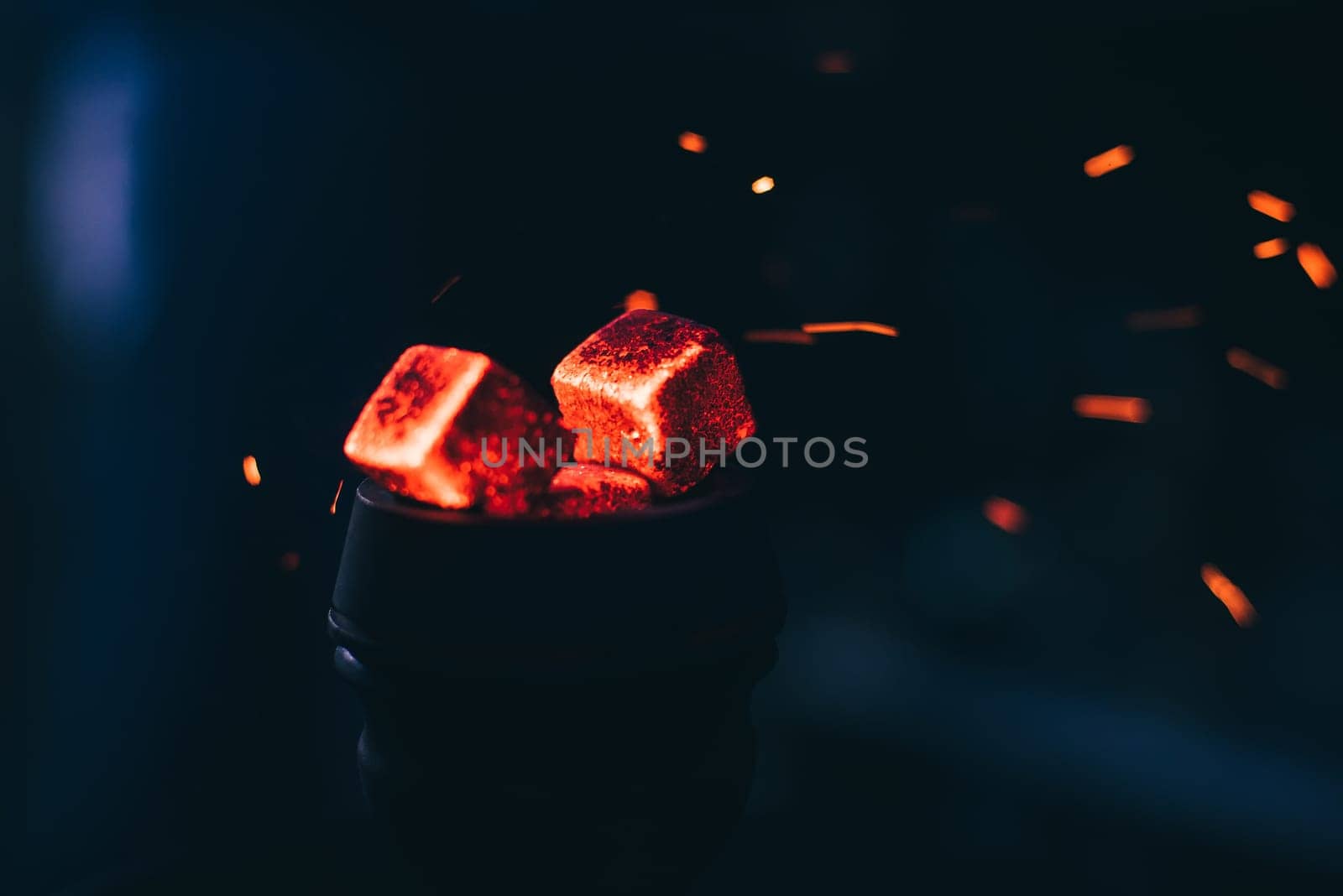hot red coals with hookah sparks in metal bowl for Shisha Smoking and traditional Asian relaxation close up