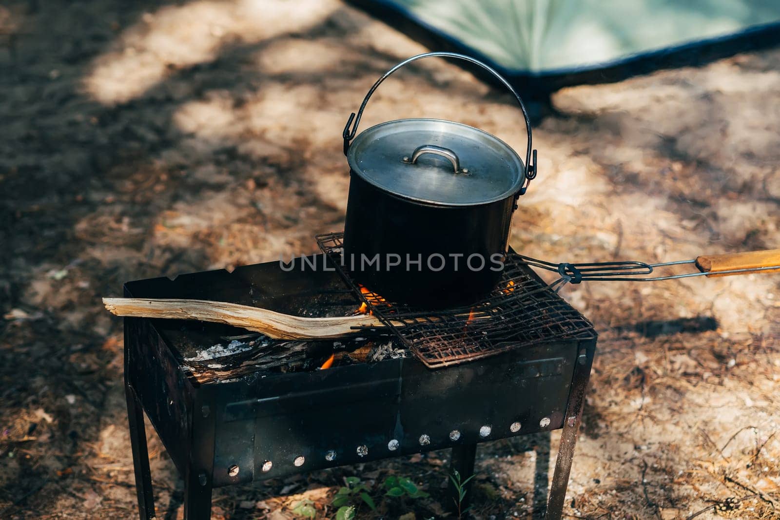 metal pot of food heated on a fire camping trip on summer vacation
