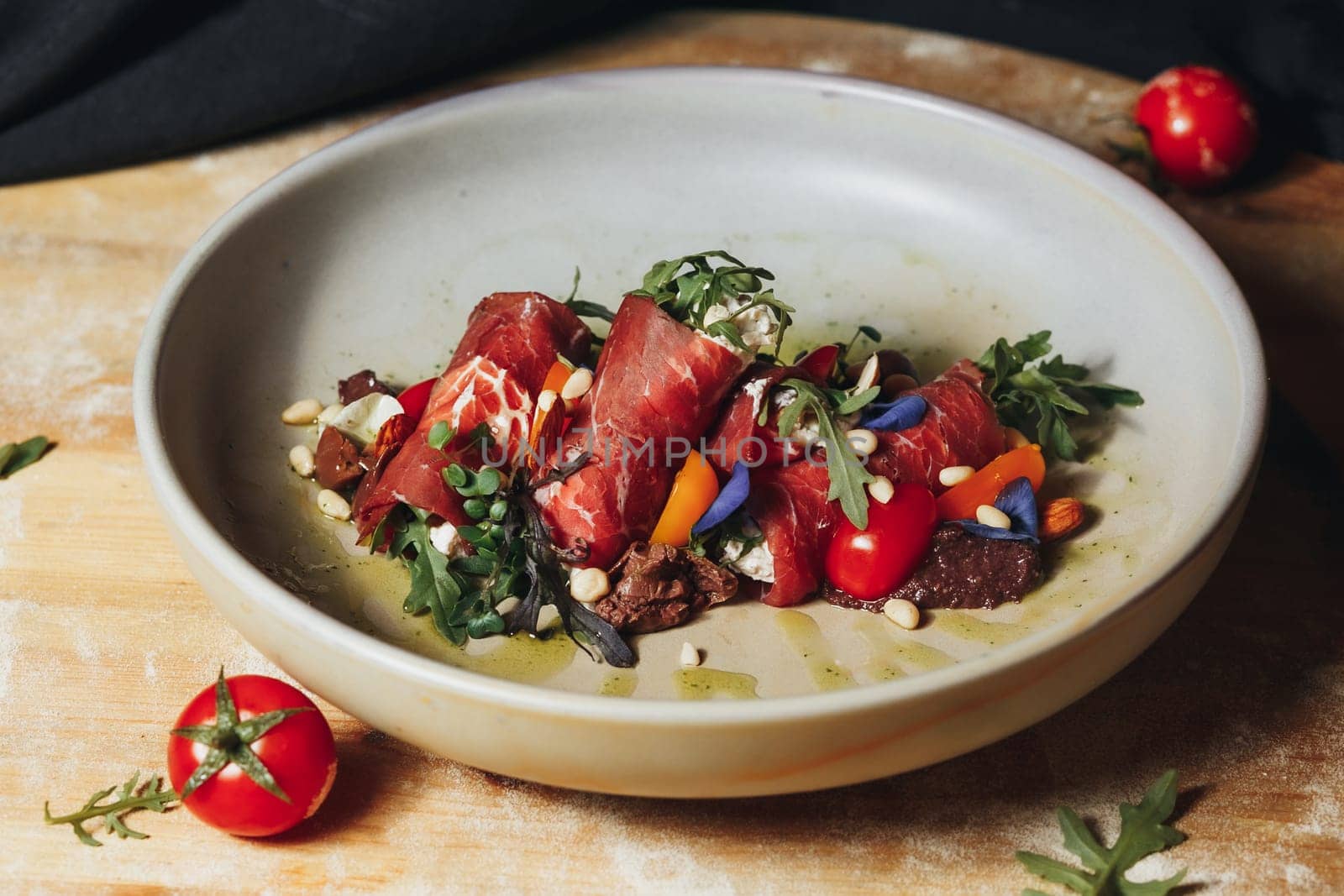 Juicy meat and colorful vegetables are elegantly presented in a bowl resting on a charming wooden cutting board.