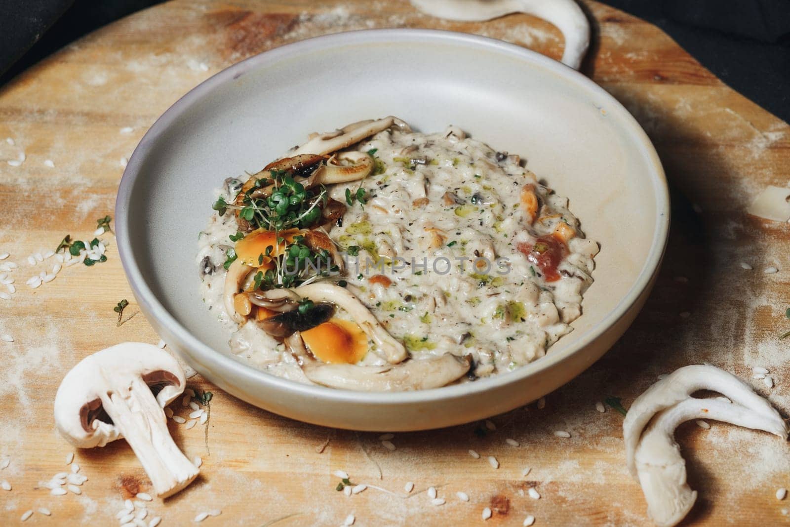 A delicious bowl of mushroom risotto resting on a rustic wooden cutting board.