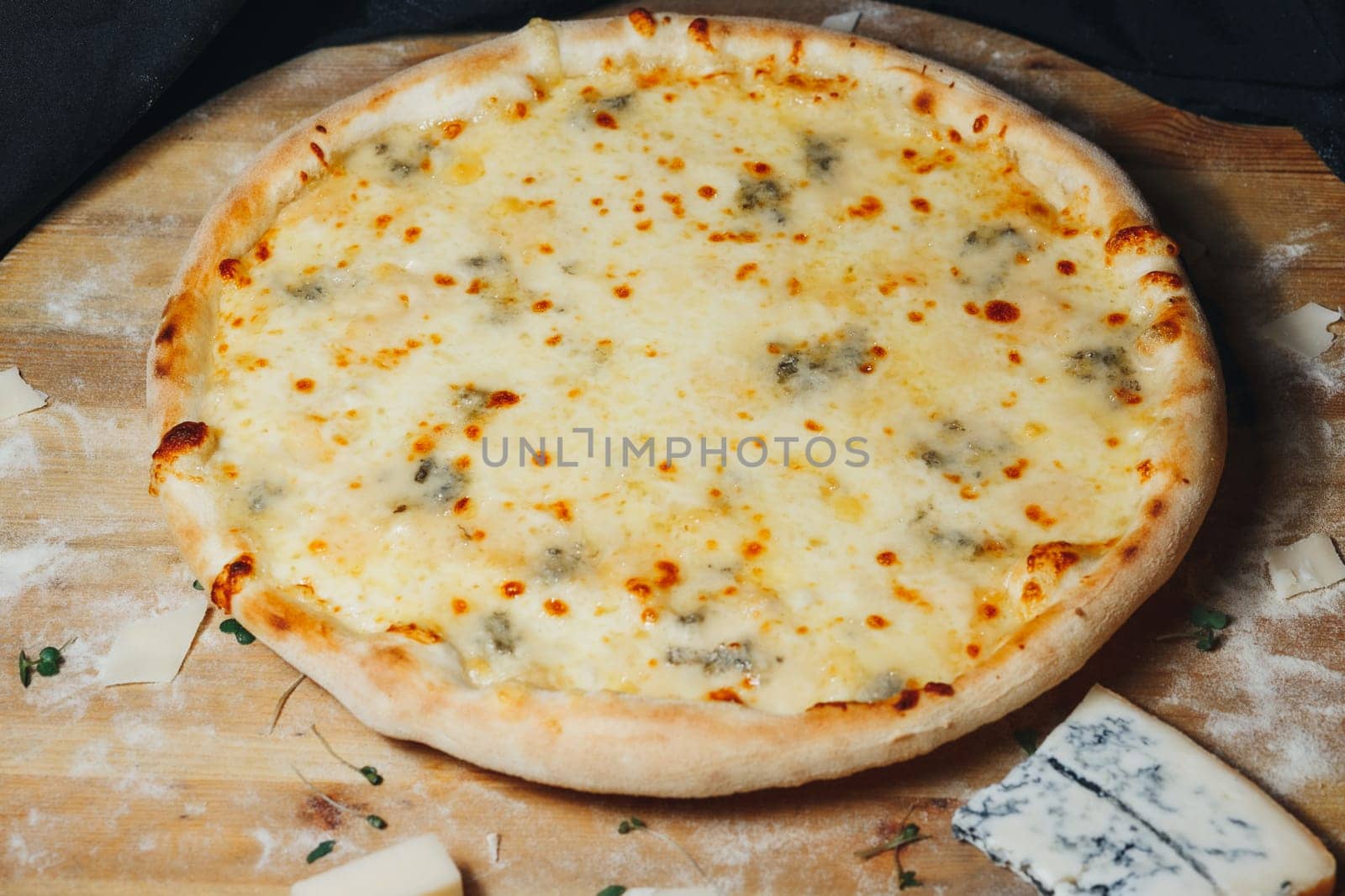 A freshly baked pizza topped with gooey melted cheese sits on a rustic wooden cutting board.