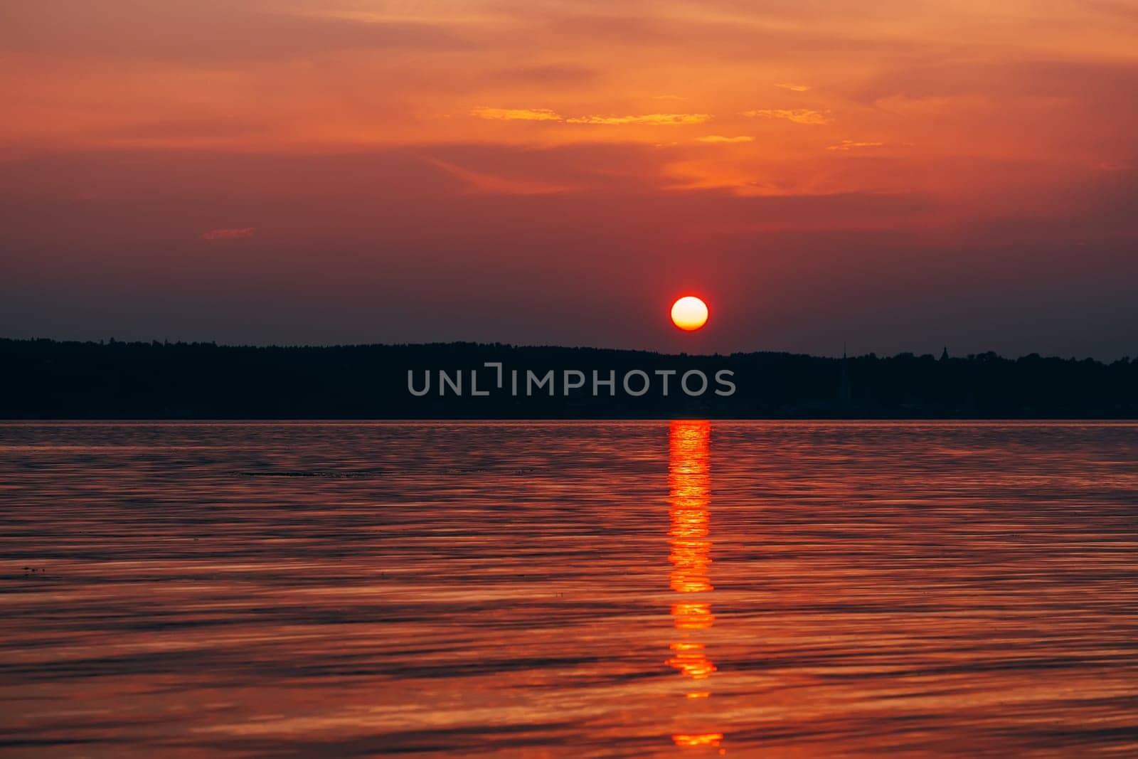 big red sun at sunset with orange sky over the sea
