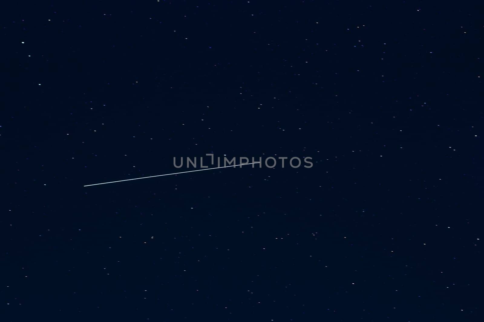 shooting star against a dark blue starry night sky