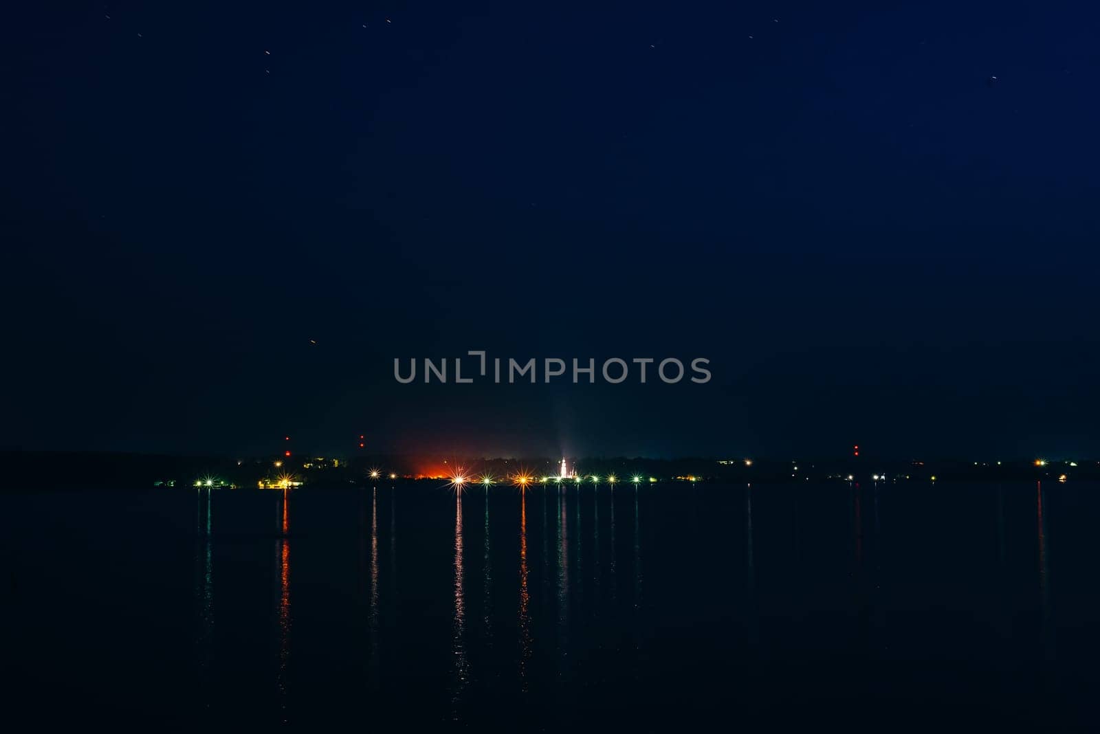 night city night on the river with reflection in the water under the starry sky