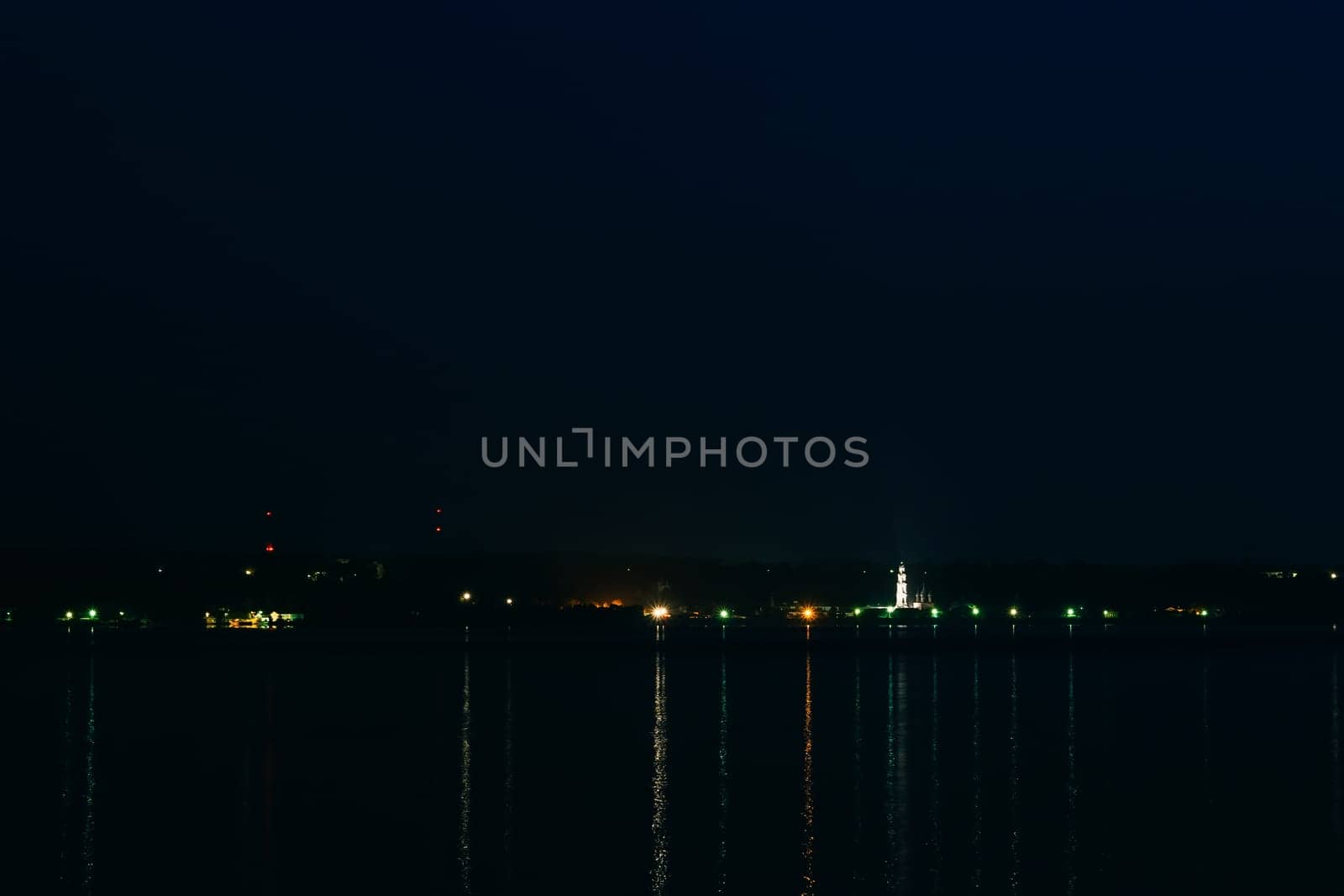 night city with the Church of the dark night reflected in the water of the river