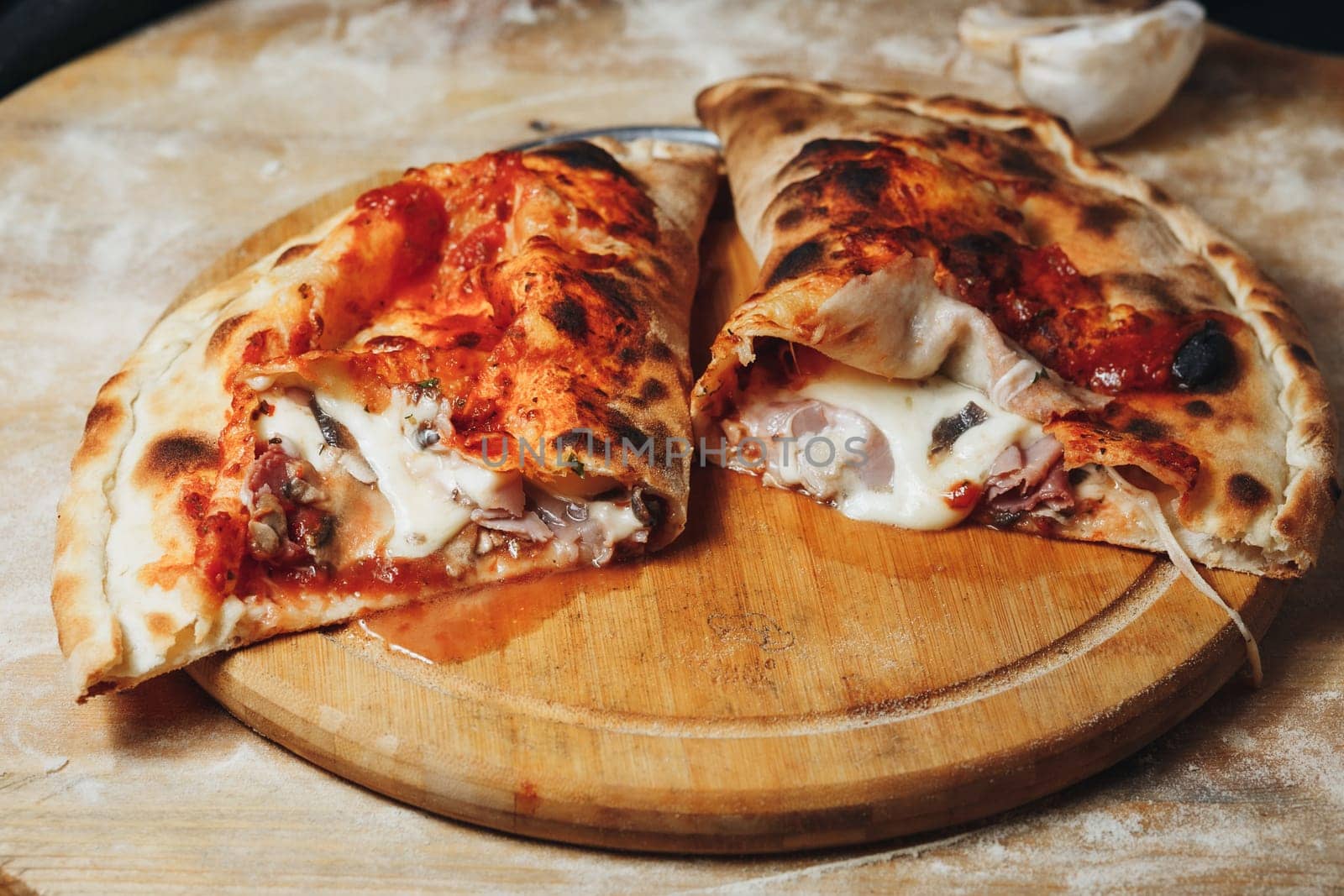 Two mouth-watering pizza slices rest on a rustic wooden cutting board.