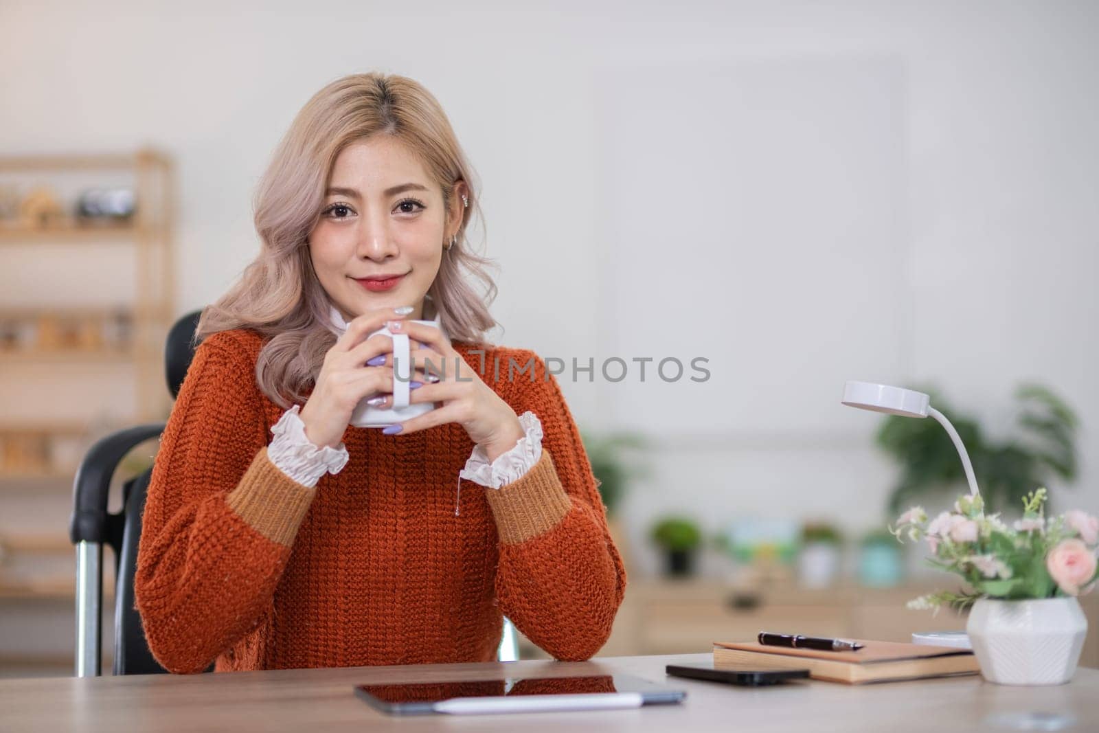 Beautiful young woman drinks coffee and tea in the morning Sit back and relax in the living room. by wichayada