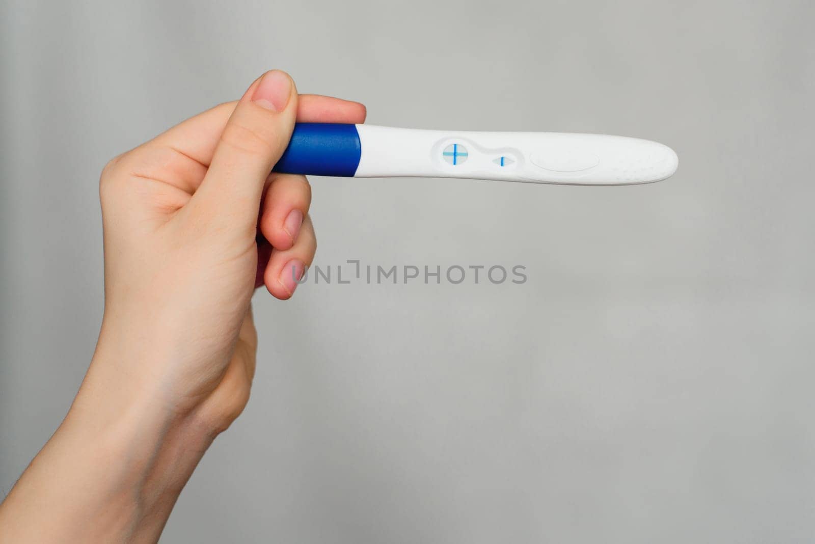 positive pregnancy test in the hands of a girl close-up