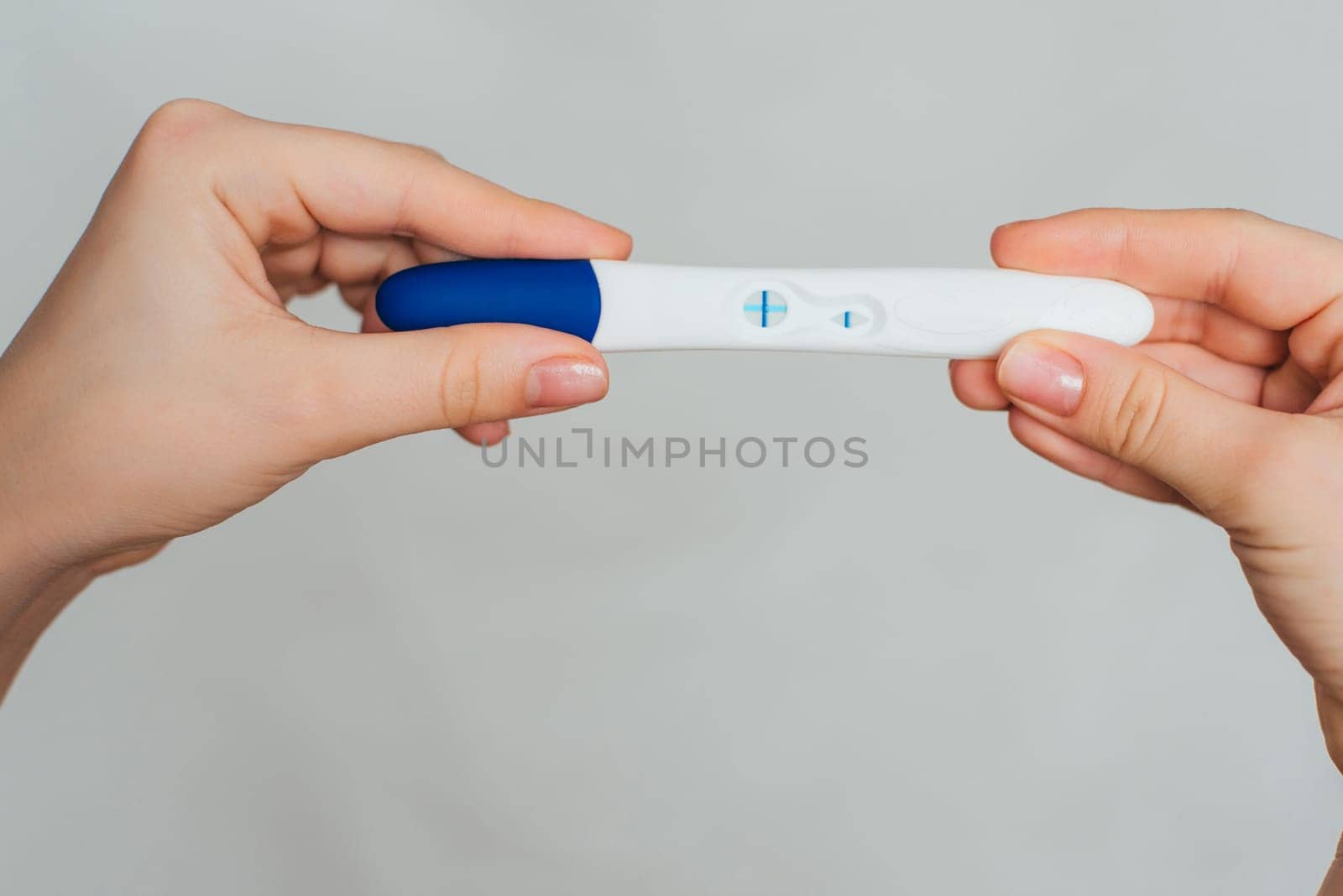 pregnancy test in the hands of a girl with a positive result close up