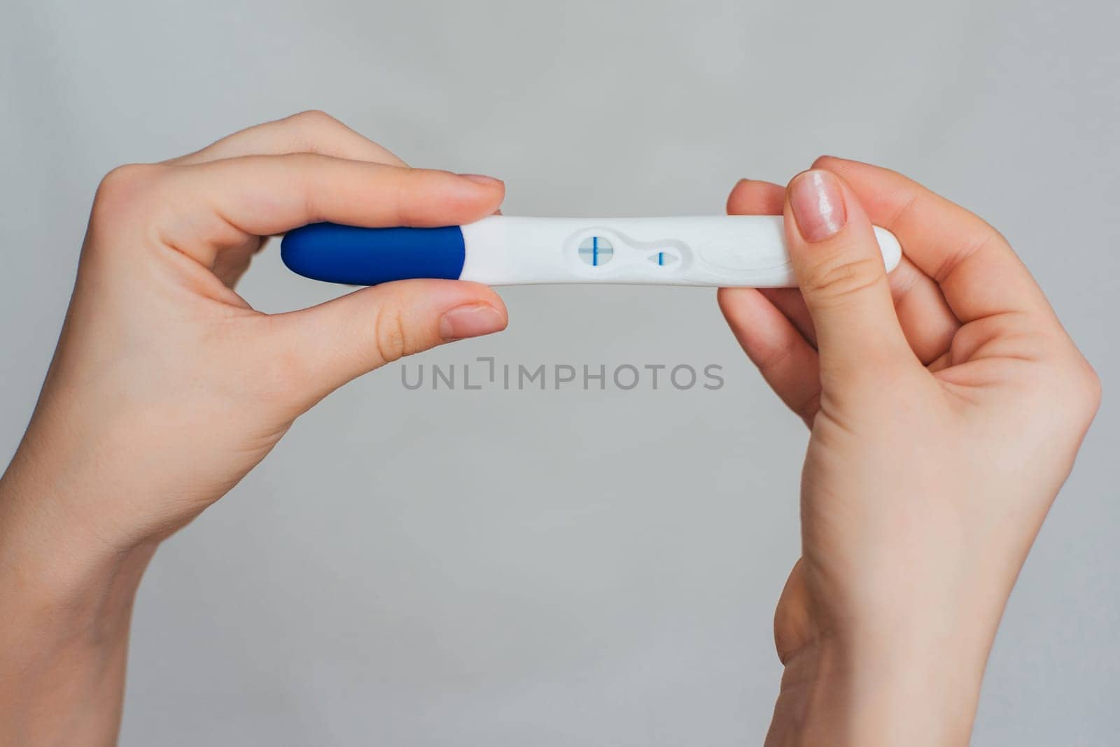 pregnancy test in the hands of a girl with a positive result close up
