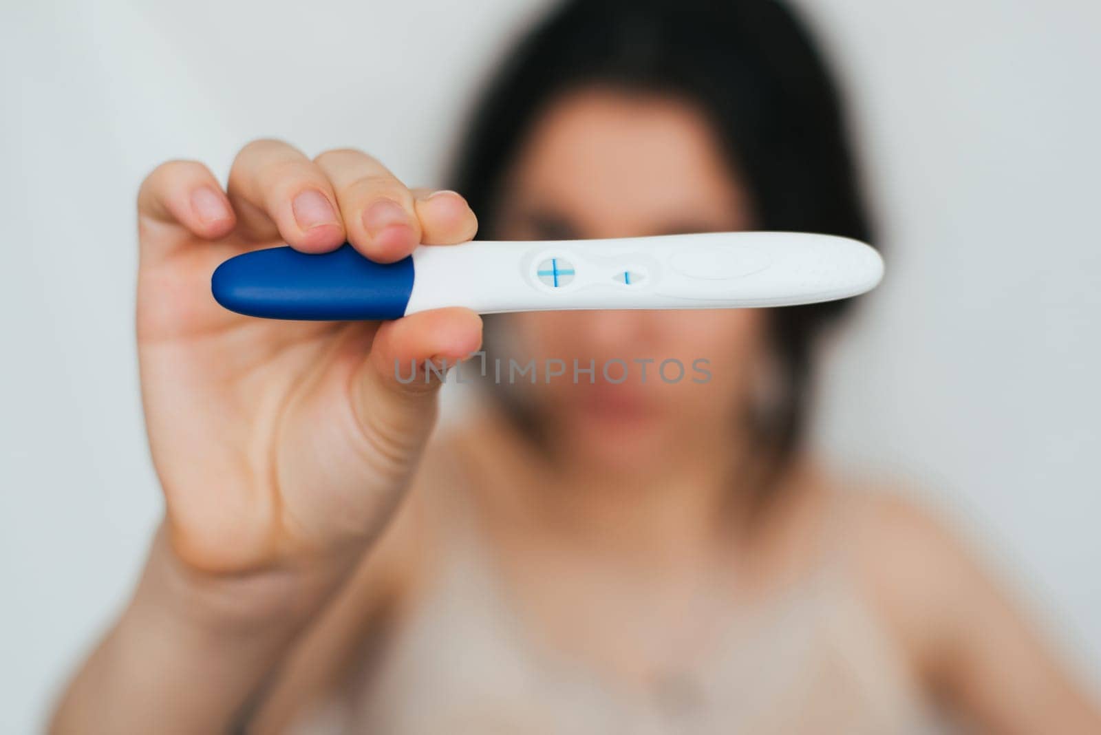positive pregnancy test in hands of happy girl close up