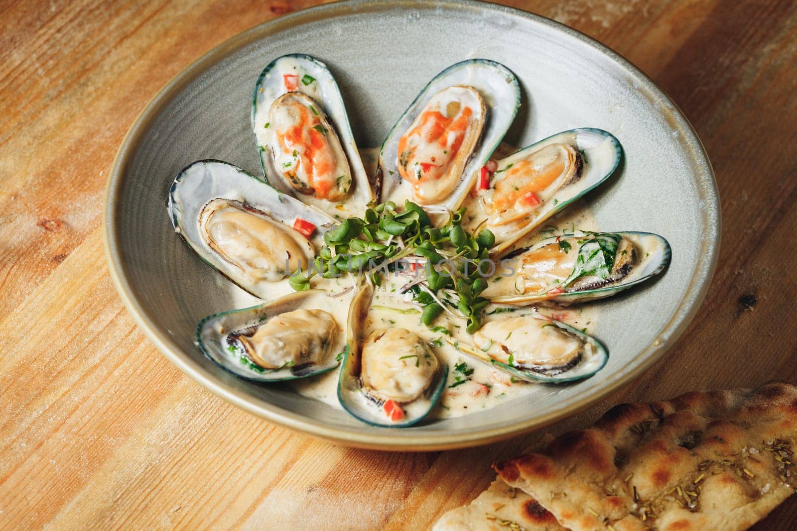 A rustic wooden table adorned with a bowl overflowing with fresh, steamed mussels, evoking the essence of a seaside feast.