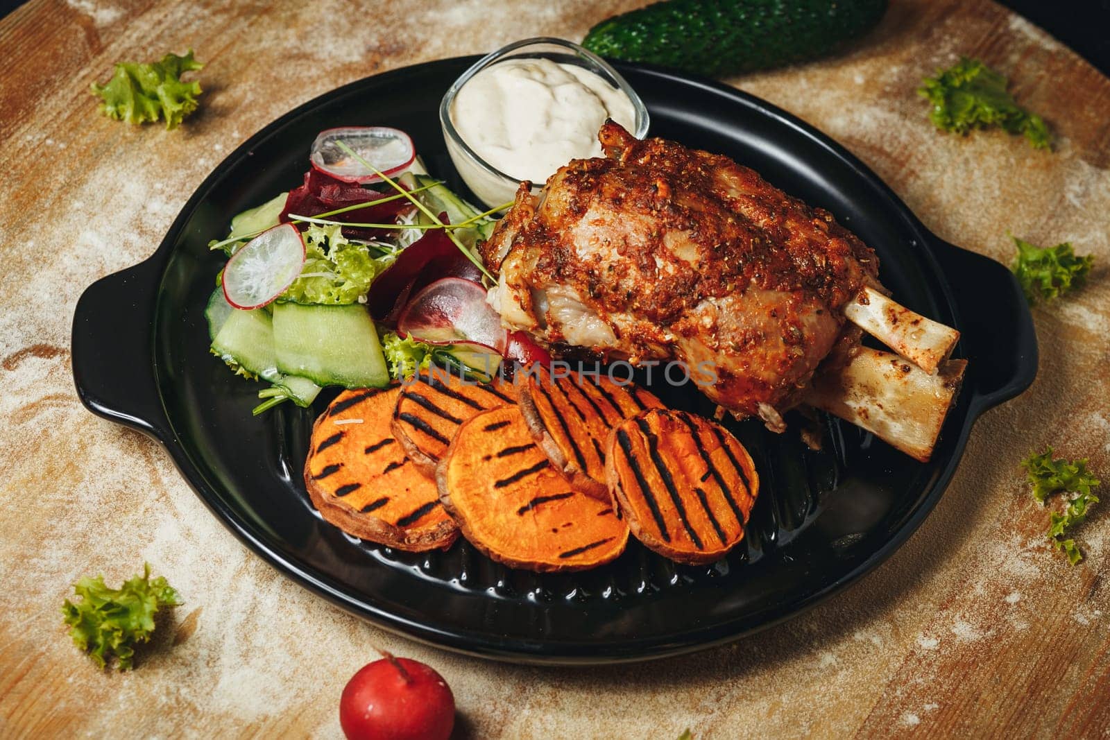 A beautifully arranged plate of meat and vegetables rests on a wooden table, showcasing a delicious and wholesome meal.