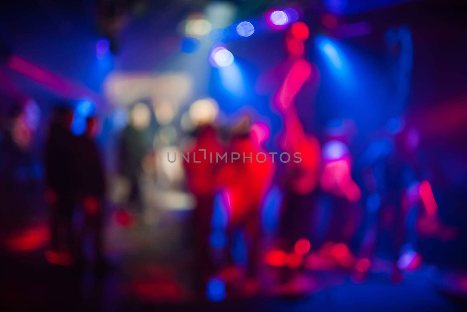 blurred abstract background with colorful bokeh from bright spotlights in a nightclub