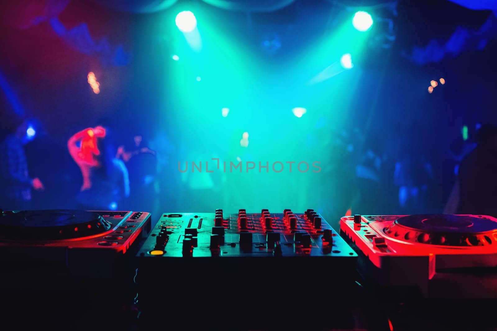 music mixer controller in DJ booth on dance floor background in night club at party