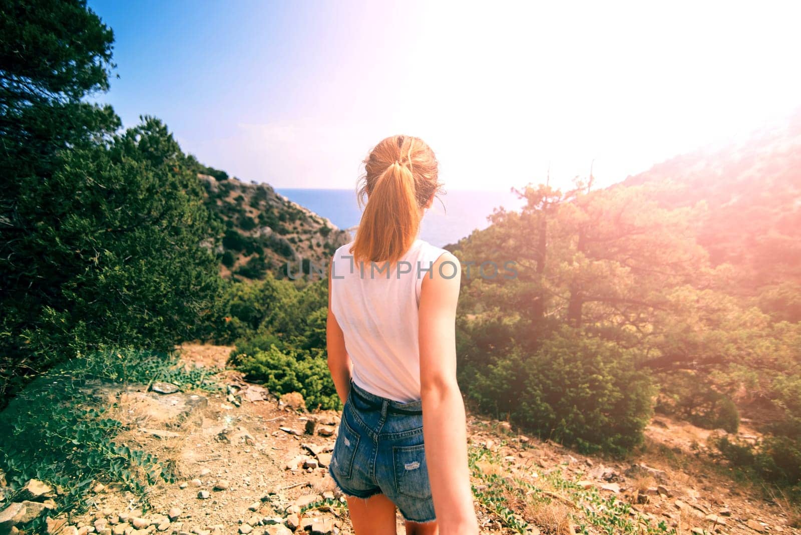 girl holds her boyfriend hand on vacation on a Sunny day in the background of the mountains and the sea