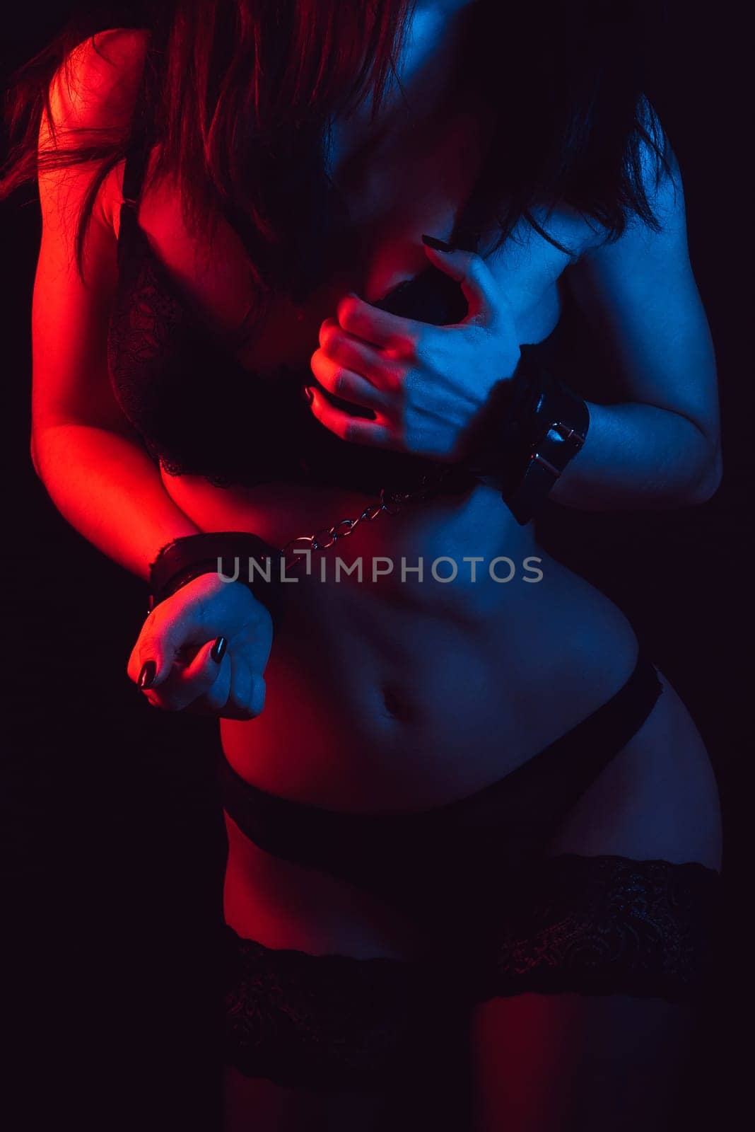 fitness body of a young girl with sexy attractive forms of Breasts and ass in underwear and stockings with handcuffed hands. BDSM concept of sex with submission and domination, role-playing games