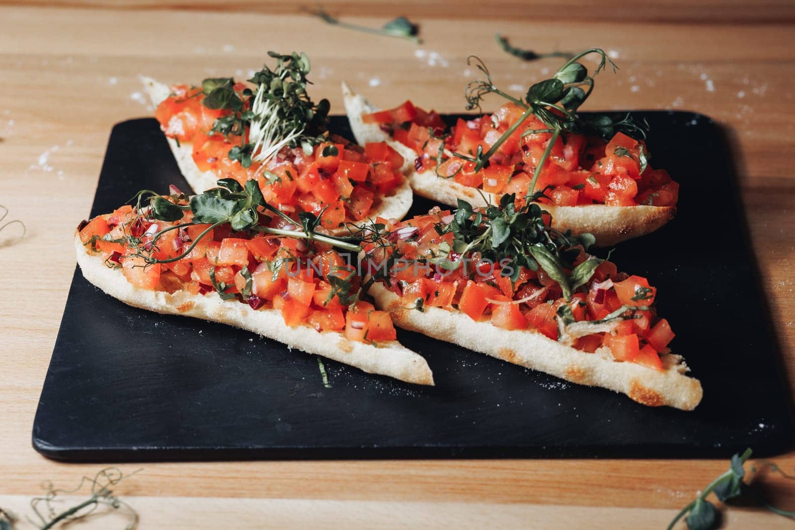 A plate brimming with freshly made bruschetta topped with juicy tomatoes and fragrant herbs, enticing the viewer with its vibrant colors and savory aroma.
