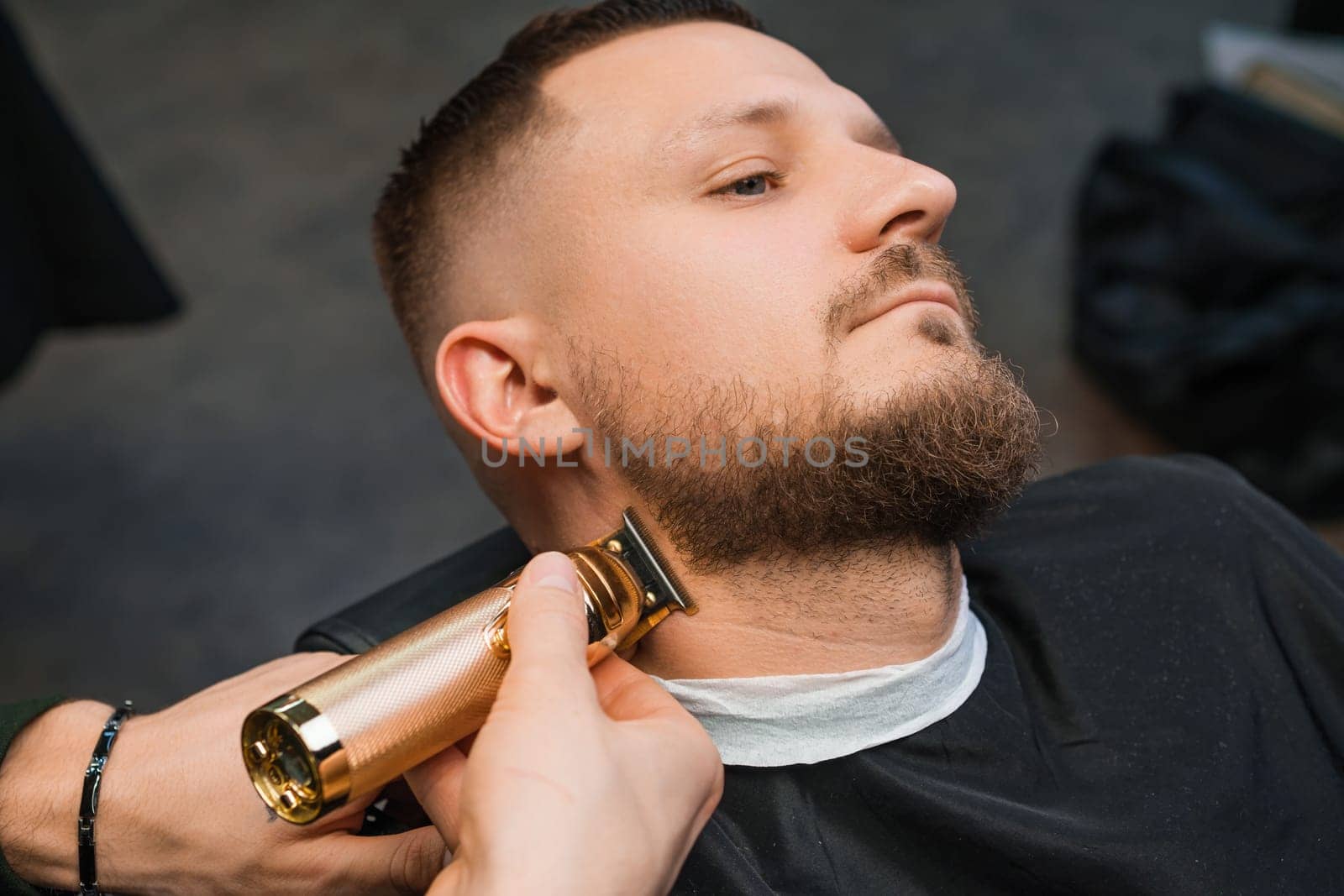 Stylist uses trimmer and comb to cut with client beard by vladimka