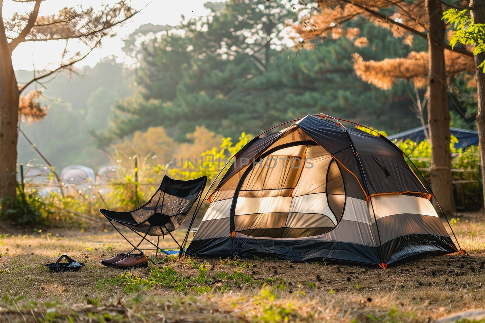 Camping outdoors with lots of sunlight. tent, chairs, a tent BBQ rack, and more.