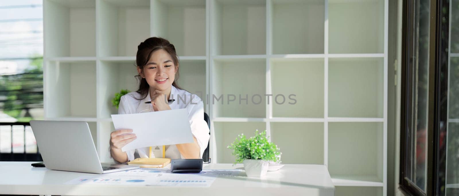 Business accounting woman counting on calculator working on financial document in hands closeup. Bookkeeping concept.