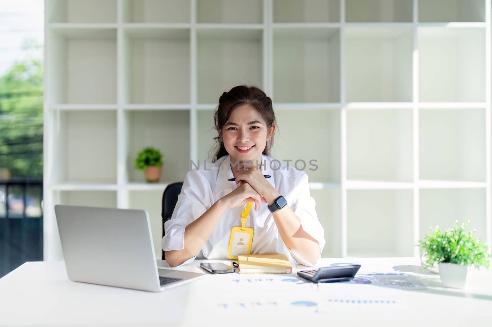 Business woman asian working about financial with business report and calculator on laptop in office.
