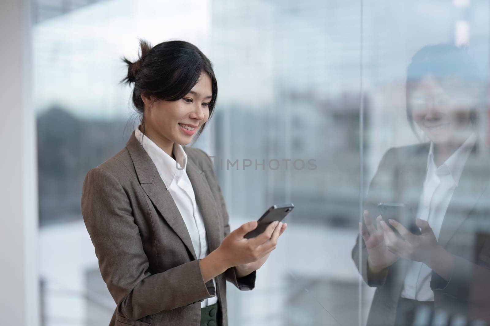 Business woman asian happy businesswoman use smartphone in office by nateemee