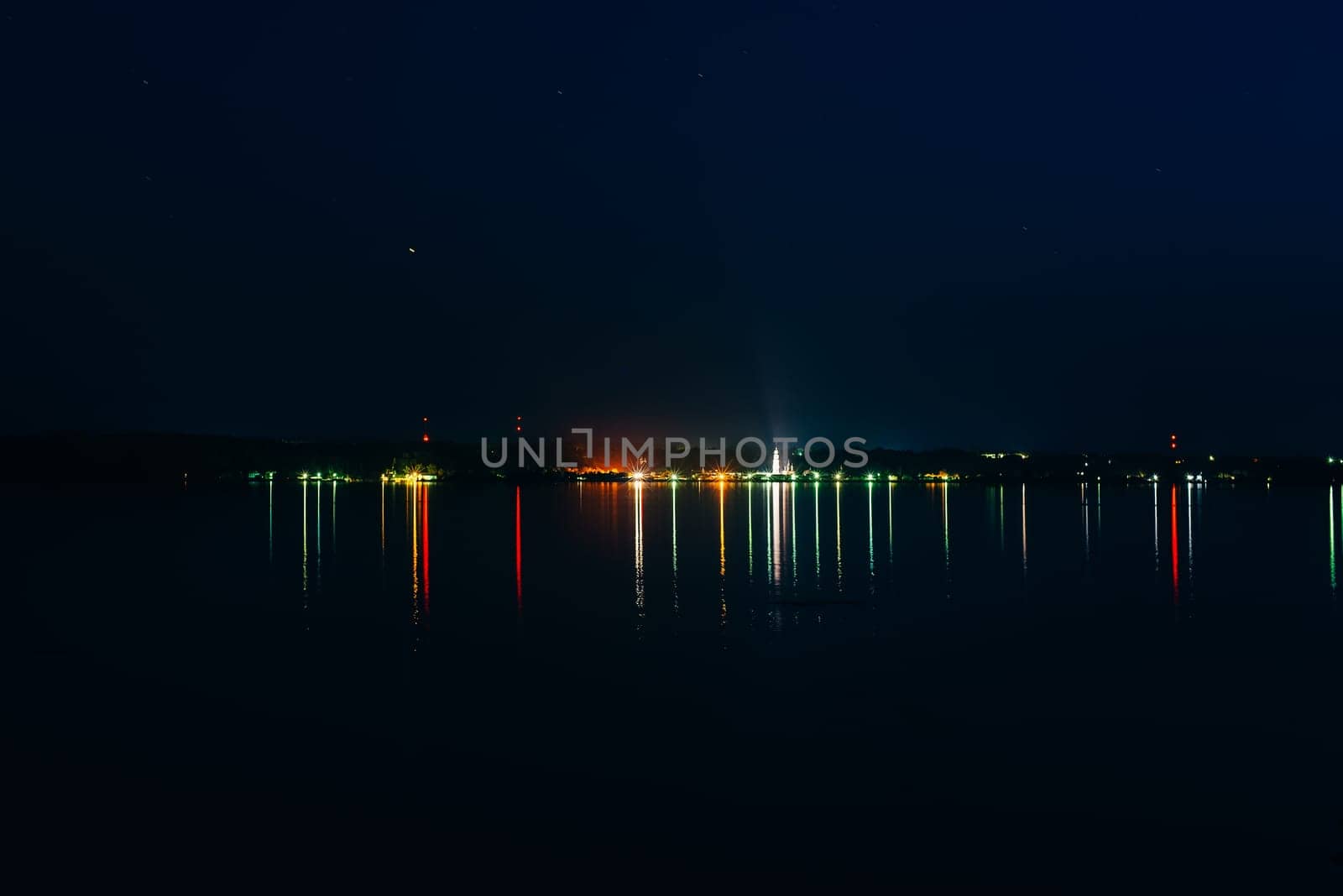 city on the river with beautiful reflection in water at night under the starry sky