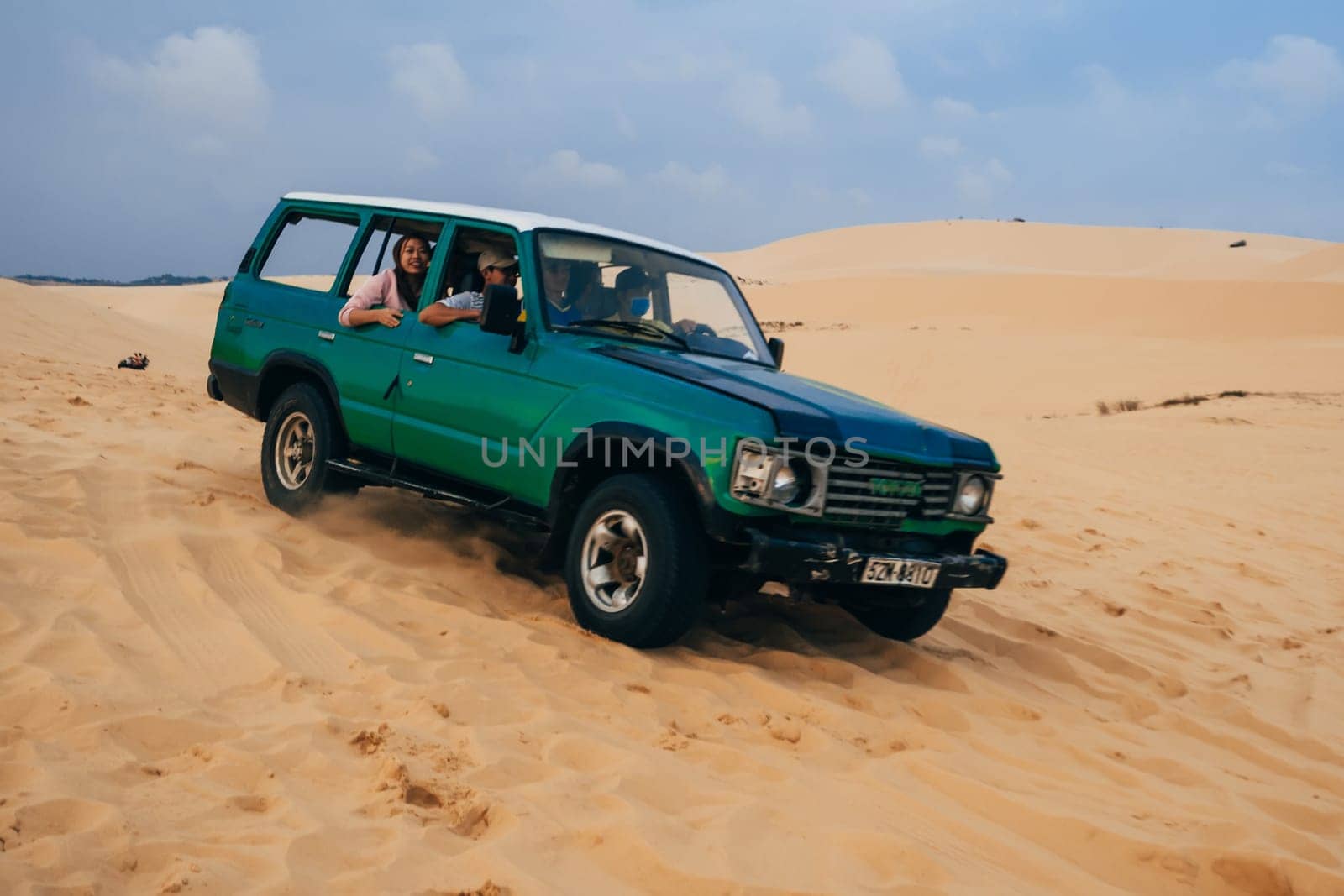 MUI NE, VIETNAM - MARCH 6, 2017: Tourists ride in a jeep in the White Sand Dunes Muine in Vietnam in the summer