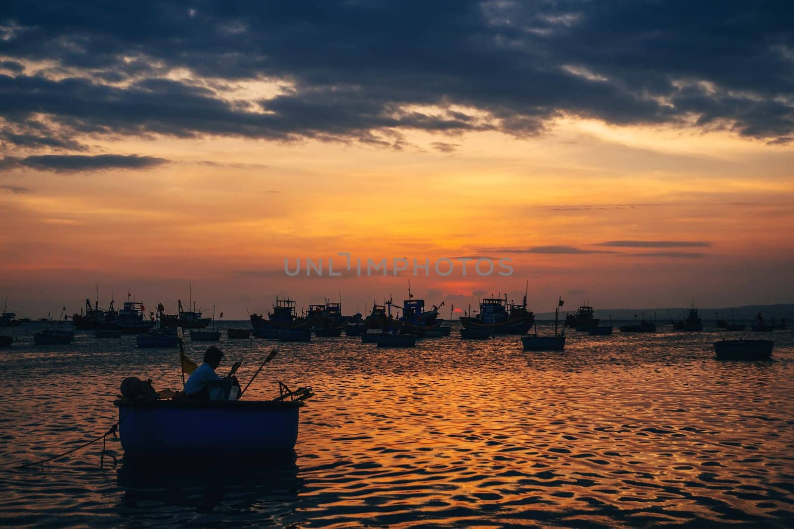 traditional boats for sea fishing in Vietnam in Mui Ne on the background of the orange sunset